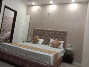 um quarto com uma cama grande e um espelho em City Palace em Panchkula
