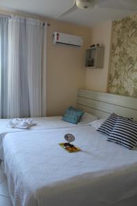 two beds in a hotel room with a plate on the bed at Lindo Apartamento pé na areia com serviço de limpeza in Lauro de Freitas