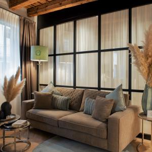 ein Wohnzimmer mit einem Sofa und großen Fenstern in der Unterkunft ELEGANCE ROOM - Aparta & Suite - Automatized Apartment in Bassano del Grappa