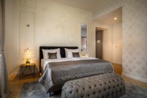 a bedroom with a large bed and a ottoman at Hotel Imperial - Liburnia in Opatija