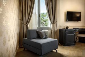 a chair in a room with a desk and a television at Hotel Imperial - Liburnia in Opatija