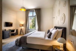 a bedroom with a bed and a desk and a window at Hotel Imperial - Liburnia in Opatija