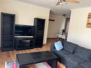 a living room with a couch and a flat screen tv at House 210 holiday rentals in Alberton