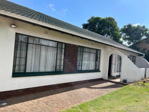 a brick house with a door and a window at House 210 holiday rentals in Alberton