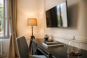 a desk with a lamp and a television on a wall at Hotel Imperial - Liburnia in Opatija