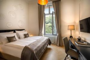 a bedroom with a bed and a desk and a television at Hotel Imperial - Liburnia in Opatija