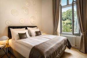 a bedroom with a large bed and a window at Hotel Imperial - Liburnia in Opatija