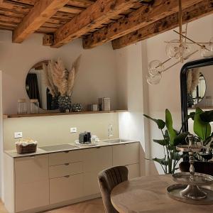 eine Küche mit einem Tisch und einem Spiegel in der Unterkunft ELEGANCE ROOM - Aparta & Suite - Automatized Apartment in Bassano del Grappa