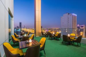 a restaurant with tables and chairs and a view of a city at Al Malqa Elite Hotel in Riyadh