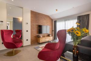 马拉加Home Art Apartments Soho的客厅里有两把红椅子和一台电视