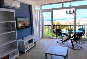 een woonkamer met een tafel en uitzicht op de oceaan bij Wonderful Apartment Capri in Nerja