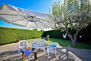 eine Terrasse mit 2 Stühlen und einem Sonnenschirm in der Unterkunft I CINQUE TRULLI with Swimming Pool in Martina Franca