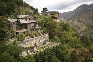 une maison sur le flanc d'une montagne dans l'établissement Apartamento Chalet en Casa Rural Camp de Claror, à Sant Julià de Lòria