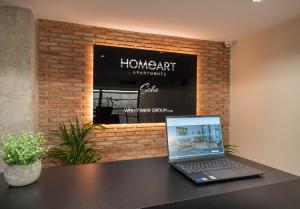 een laptop op een tafel voor een stenen muur bij Home Art Apartments Soho in Málaga