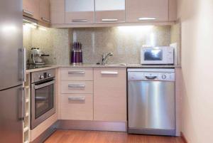 a kitchen with a stainless steel refrigerator and a microwave at Centro de Canillo GRANDVALIRAMONT MAGIC in Canillo