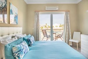 a bedroom with a blue bed and a balcony at Beach House Ericeira in Ericeira