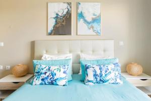 a bedroom with a bed with blue and white pillows at Beach House Ericeira in Ericeira