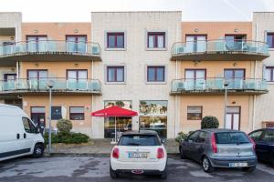 a building with cars parked in a parking lot at Beach House Ericeira in Ericeira