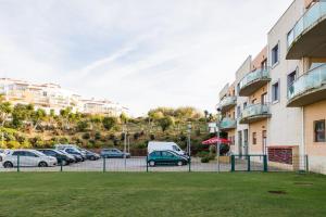 a parking lot with cars parked next to a building at Beach House Ericeira in Ericeira