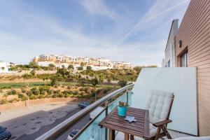 a balcony with a table and a chair and a view at Beach House Ericeira in Ericeira