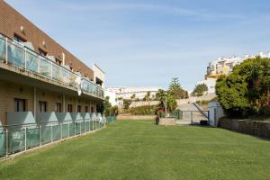 a large green lawn in front of a building at Beach House Ericeira in Ericeira