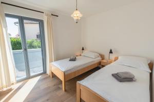 a bedroom with two beds and a large window at Kuntrada 45 Holiday Home - Heated & Kids Pool in Fažana +32 photos