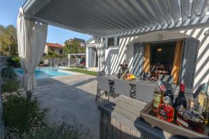 a patio with a pergola next to a pool at Kuntrada 45 Holiday Home - Heated & Kids Pool in Fažana