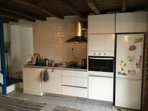 a kitchen with white cabinets and a refrigerator at Casa da Carvalha - Ádela in Açor