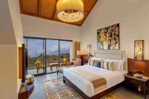 Storii By ITC Hotels, Amoha Retreat Dharamshala في دارامشالا: غرفة نوم بسرير كبير ونافذة كبيرة