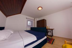 Un dormitorio con una cama blanca y una ventana. en Planinska kuća Munika, en Risovac