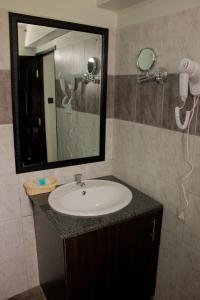 een badkamer met een wastafel en een spiegel bij Hadassah Hotel in Nairobi