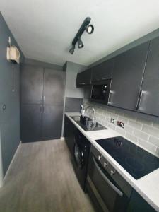 a small kitchen with a sink and a dishwasher at Central 2 bed apartment in Wolverhampton