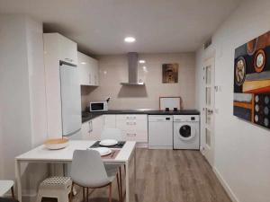 kuchnia z białymi szafkami, stołem i krzesłami w obiekcie San José Apartamentos Turísticos Karlie w mieście Albacete +8 zdjęć