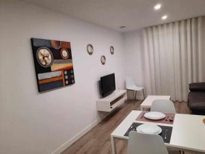 salon ze stołem i telewizorem na ścianie w obiekcie San José Apartamentos Turísticos Karlie w mieście Albacete