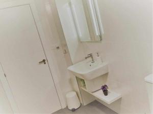 biała łazienka z umywalką i prysznicem w obiekcie San José Apartamentos Turísticos Karlie w mieście Albacete