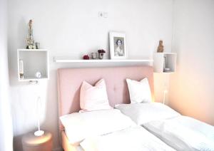 um quarto com 2 camas e almofadas brancas em Malvasia Apart em Stumm