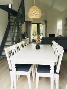 a white dining table and chairs in a living room at Kustverhuur, Park Schoneveld, Strandparel 357 in Breskens
