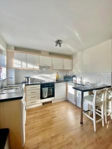 a kitchen with white cabinets and a table and chairs at Chase Heights in Rugeley