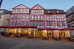 a large building with tables and chairs in front of it at Hotel Schlemmer in Montabaur