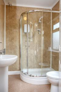 a bathroom with a shower and a toilet and a sink at The Seacliffe - Whitby in Whitby