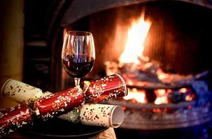 a glass of wine and some chocolates next to a fireplace at The Lifeboat Inn in Hunstanton