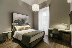 um quarto com uma cama, uma escrivaninha e uma janela em Royal Collection Covilh na Covilh