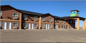 a large building with a parking lot in front of it at SureStay Hotel by Best Western Bassano in Bassano