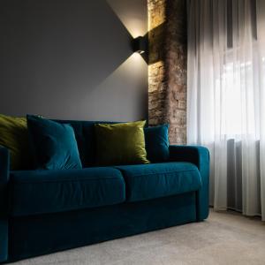 ein blaues Sofa im Wohnzimmer mit Fenster in der Unterkunft The Baltic Hotel in Liverpool