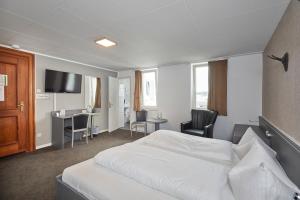 a hotel room with a white bed and a desk at Hotel Schlemmer in Montabaur