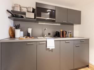 a kitchen with stainless steel cabinets and a microwave at limehome Bremen Hutfilterstraße in Bremen