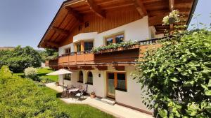 Cette maison dispose d'un balcon avec une table et des chaises. dans l'établissement Ferienwohnung Aschaber, à Wildschönau