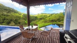 a table and chairs on a deck with a view at Chalé do Lago super Luxo in Cunha