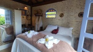 a bedroom with a bed with towels on it at Chalé do Lago super Luxo in Cunha +98 photos