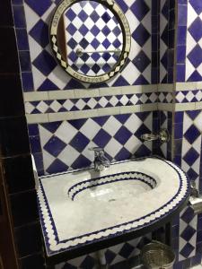La salle de bains est pourvue d'un lavabo et d'un miroir. dans l'établissement Riad le petit ksar, à Meknès